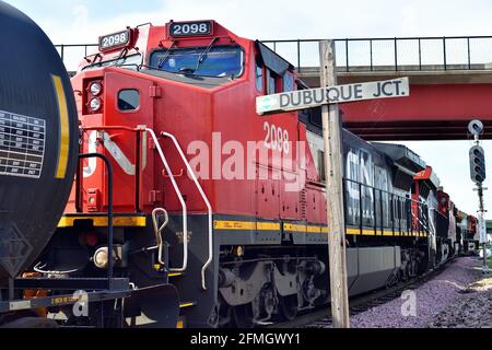 Dubuque, Iowa, Stati Uniti. Quattro unità conducono un treno di trasporto ferroviario nazionale canadese appena dopo che ha lasciato un cantiere di trasporto locale. Foto Stock
