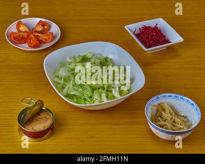 Ingredienti per la preparazione di tonno e insalata di vegan verde su sfondo di legno. Foto Stock