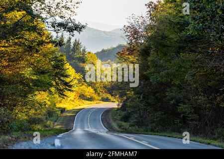 Punto di vista dell'auto su una tortuosa e tortuosa autostrada panoramica sull'altopiano Strada in autunno colorato autunno a West Virginia a Monongahela foresta nazionale con tramonto o. Foto Stock