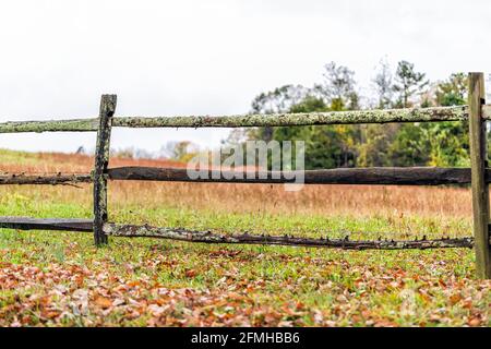 Virginia rurale campagna fattoria con recinzione in legno tradizionale da agricoltura campo in primavera o in autunno con foglie brune secche cadute Foto Stock