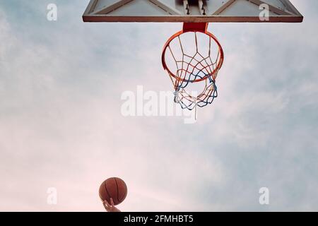 La mano getta il basket al cerchio Foto Stock