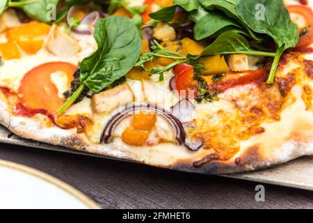 Pizza fresca fatta a mano con formaggio cipolla spinaci pomodoro e pollo Foto Stock