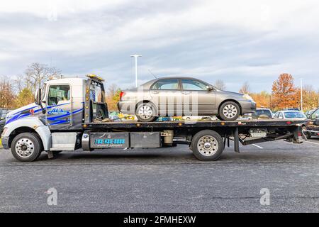 Sterling, Stati Uniti - 21 novembre 2020: Automobile nel camion del veicolo di traino della torre a causa della perdita di carburante danno di sicurezza nel parcheggio della Virginia dal negozio di riparazione auto Foto Stock