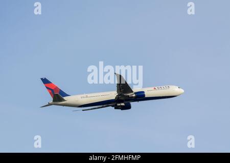 Delta Air Lines Boeing 767 jet Airliner aereo N833MH che sale dopo il decollo dall'aeroporto Heathrow di Londra in cielo blu chiaro. Lungo raggio verso gli Stati Uniti Foto Stock