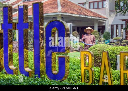 Giardino vietnamita annaffiatura giardino con tubo esterno bar ristorante a Hoi An, Vietnam Foto Stock