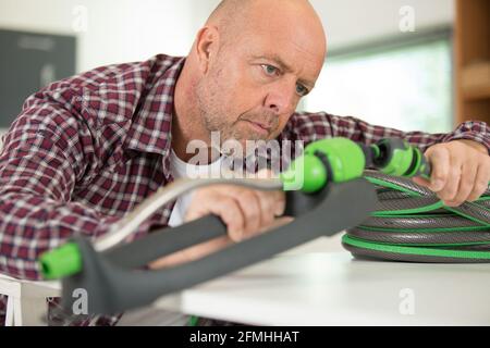 uomo montaggio tubo di irrigazione Foto Stock