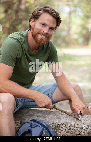 uomo abile che sbianca il palo nella foresta Foto Stock