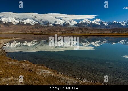 Montagna del Pamir si riflette nel Lago Karakul sulla Karakoram Highway, provincia dello Xinjiang, Cina Foto Stock