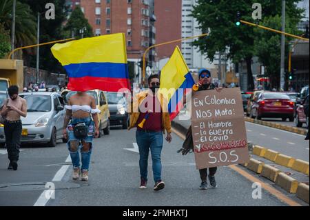 Bogota, Cundinamarca, Colombia. 9 maggio 2021. Un dimostratore ha un segno che recita ''in Colombia, fame, guerra, COVID-19 e il governo ci uccide'' mentre le comunità di LGTB e Trans conducono manifestazioni mentre migliaia di persone inondano il centro di Bogotà, Colombia in una dimostrazione contro il conteggio dei morti in casi di brutalità della polizia che hanno portato a 30 morti in tutto il paese durante le manifestazioni e la riforma sanitaria del presidente Ivan Duque Marquez il 9 maggio 2021. Foto di: Chepa Beltran/Long Visual Press via ZUMA Wire Credit: Chepa Beltran/LongVisual/ZUMA Wire/Alamy Live News Foto Stock