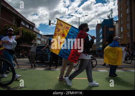 Bogota, Cundinamarca, Colombia. 9 maggio 2021. Un dimostratore cammina con una bandiera colombiana stampata con il messaggio ''ci stanno uccidendo'' mentre le comunità di LGTB e Trans conducono dimostrazioni mentre migliaia inondano il centro di Bogotà, Colombia in una dimostrazione contro il conteggio dei morti in casi di brutalità della polizia che hanno portato a 30 morti in tutto il paese durante le manifestazioni e la riforma sanitaria del presidente Ivan Duque Marquez il 9 maggio 2021. Foto di: Chepa Beltran/Long Visual Press via ZUMA Wire Credit: Chepa Beltran/LongVisual/ZUMA Wire/Alamy Live News Foto Stock