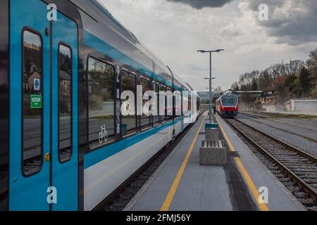 Treno passeggeri vecchio e nuovo su una piattaforma. Concetto di modernizzazione del materiale rotabile sulle ferrovie. Foto Stock