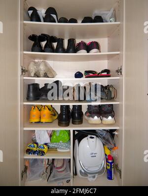 Hong Kong - 10 Maggio 2021: Rastrelliera per scarpe piegate in un armadietto per scarpe con molte scarpe Foto Stock
