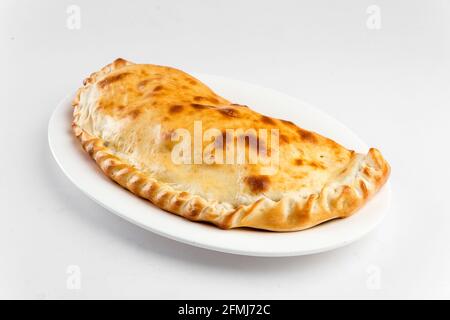 Piatto isolato di pizza italiana piegata di calzone Foto Stock