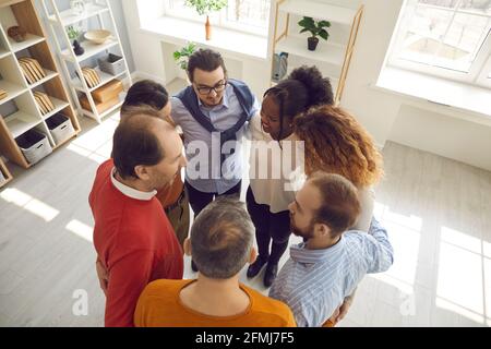 Foto di gruppo ad alto angolo di partner commerciali felici e diversificati e. colleghi che si accanono in ufficio Foto Stock