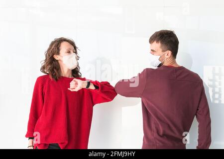 Due persone salutano il gomito. Saluto con gomito in strada. I colleghi stanno facendo colpi di gomito in ufficio. Nuovo stile di saluto durante il coronavirus. Foto Stock