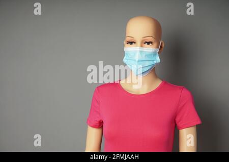 conservare il manichino della finestra o esporre il manichino indossando la maschera medica Foto Stock