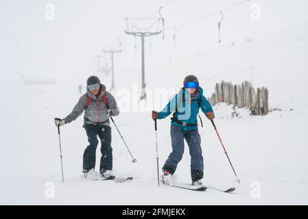 Sciatori di backcountry sulle piste presso il centro sciistico vicino Aviemore dopo le forti nevicate notturne nel Cairngorms National Park, Scozia, Regno Unito Foto Stock