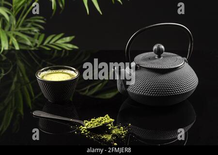 Polvere di tè Matcha e accessori per il tè su sfondo nero. Cerimonia del tè. Bevanda tradizionale giapponese. Foto Stock