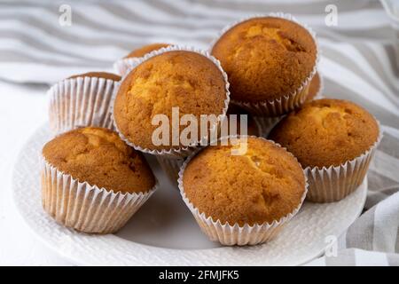 Primo piano con muffin biscotti. Dolci. Festa. Dessert su tavola bianca - muffin fatti in casa. Cupcakes in porzionato. Muffin semplici. Foto Stock