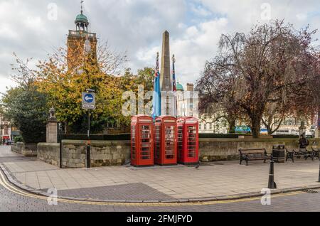 Centro di Northampton visualizza con tre cabine telefoniche rosse nella parte anteriore di un progettato Lutyens Memoriale di guerra, la chiesa di Tutti i Santi in background. Foto Stock