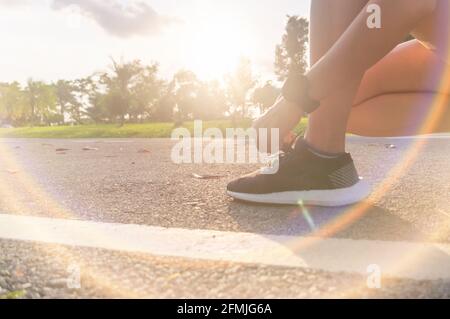 Donna indossare scarpe da running a camminare e correre sulla natura verde background.Health esercizio concetto. Foto Stock