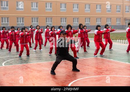Gli studenti di una scuola elementare di Lixian, Hebei, Cina, fanno il loro PE facendo esercizio di wushu. Foto Stock