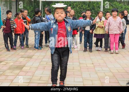 Gli studenti della scuola Lixiana di Hebei, in Cina, bilanciano un piatto e una ciotola mentre camminano verso il traguardo di una gara di relè. Foto Stock