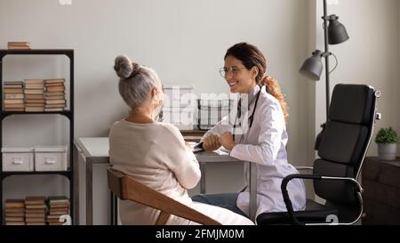 Felice donna medica informare la paziente anziana di dinamica positiva Foto Stock