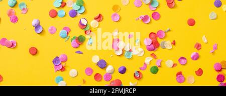 Coriandoli colorati su sfondo giallo. Foto Stock