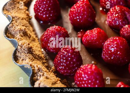Torta gourmet di ganache al cioccolato con frutti di bosco freschi, crostata di frutta fresca, torta di frutta fresca fatta in casa su un tavolo. Super macro shot con estrema selezione f Foto Stock