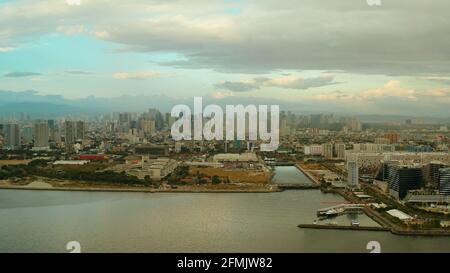 La città di Manila, la capitale delle Filippine. Metropoli moderna al tramonto, vista dall'alto. Edifici moderni nel centro della città. Foto Stock