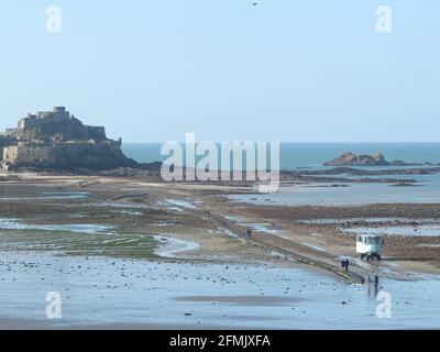 Castello di Elizabeth a St. Aubin's Bay e strada rialzata con accesso a bassa marea con traghetto anfibio sulla spiaggia in primo piano. Foto Stock