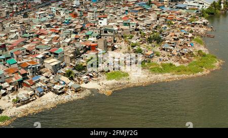 Baraccopoli di Manila vicino al porto. Fiume inquinato con plastica e spazzatura. Manila, Filippine. Foto Stock