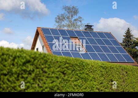 Lipsia, Germania. 03 maggio 2021. Una casa indipendente con pannelli solari sul tetto si erge dietro una siepe verde. Credit: Jan Woitas/dpa-Zentralbild/ZB/dpa/Alamy Live News Foto Stock