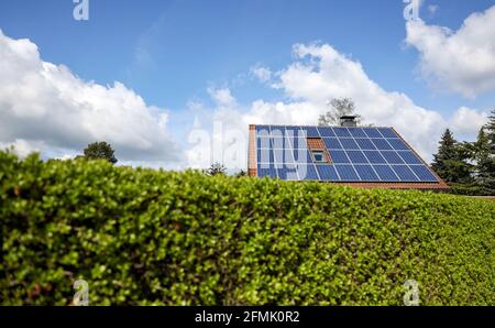 Lipsia, Germania. 03 maggio 2021. Una casa indipendente con pannelli solari sul tetto si erge dietro una siepe verde. Credit: Jan Woitas/dpa-Zentralbild/ZB/dpa/Alamy Live News Foto Stock