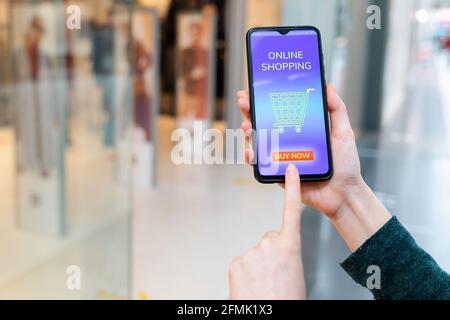 La mano di una donna mostra uno schermo di telefoni cellulari con carrello vuoto del negozio online. Primo piano. Il concetto di shopping su internet. Foto Stock