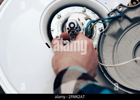 riparazione delle caldaie, la mano del master lancia e attorciglia i dadi, primo piano. Foto Stock