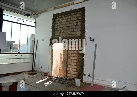 Ristrutturazione dello spazio in una sala aziendale con il posizionamento di una porta di emergenza per un accesso più facile all'uscita, foto con pareti dipinte, scale, e g Foto Stock