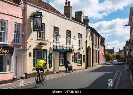 Manningtree UK, vista di un ciclista che passa accanto al pub Crown a Manningtree High Street, Essex, Inghilterra, Regno Unito Foto Stock