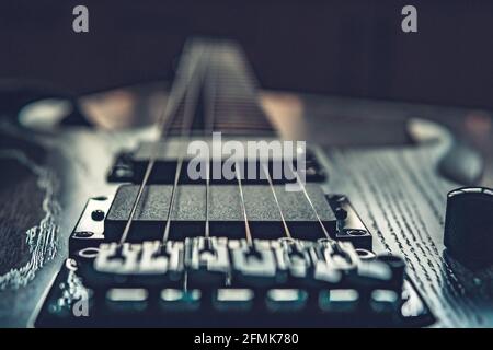 Closeup di chitarra elettrica in legno con sei corde, fuoco selettivo sulle corde Foto Stock