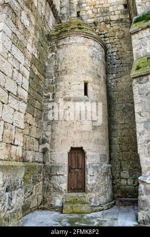 Piccola porta in legno sulla parete laterale in pietra della Chiesa di San Pietro a Montealegre del campo Foto Stock