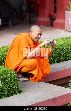 Un monaco buddista scattando una foto al Museo Nazionale Della Cambogia in Phnom Penh Foto Stock