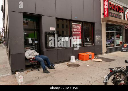 New York, Stati Uniti. 04 ottobre 2020. Un individuo senza dimora dorme di fronte ad un deposito vacante a New York sabato 8 maggio 2021. (ÂPhoto di Richard B. Levine) Credit: Sipa USA/Alamy Live News Foto Stock