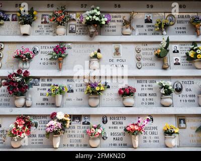 Vista closeup della tomba bianca in pietra decorata con fiori Al Cimitero di San Michele Venezia Veneto Italia Europa Foto Stock