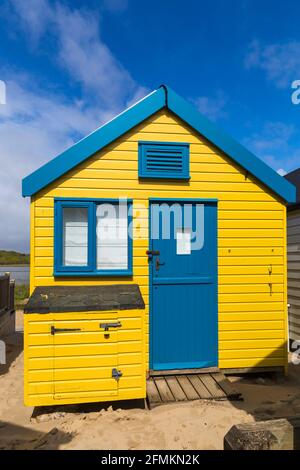 Capanna di legno gialla e blu a Hengistbury Head, vicino a Mudeford, Dorset UK nel mese di maggio Foto Stock