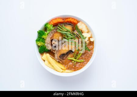 Pesce di testa di serpente fritto in zuppa acida fatta di pasta di Tamarind Con Omelet vegetale - cucina asiatica o tailandese stile isolato su sfondo bianco Foto Stock