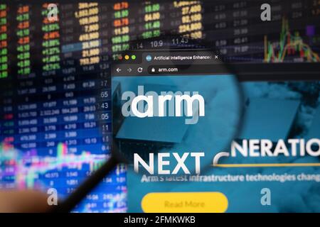 Logo aziendale di ARM Holdings su un sito Web con sviluppi sfocati del mercato azionario sullo sfondo, visto su uno schermo del computer attraverso una lente di ingrandimento Foto Stock