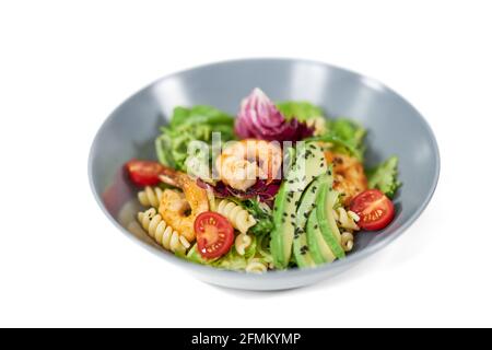 Primo piano di piatti moderni e belli con appetitosa pasta nelle verdure e con frutti di mare su sfondo bianco. Concetto di piatto delizioso con ingredienti sani per il mantenimento del peso corporeo. Foto Stock