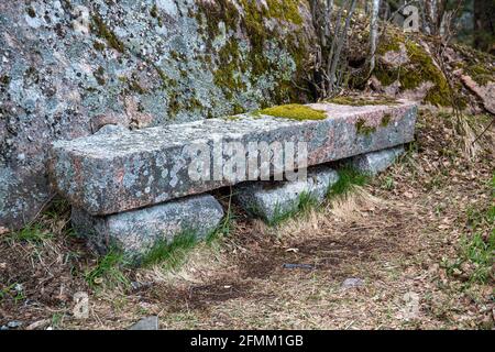 Panca di pietra ricoperta di muschio e licheni nell'isola di Seurasaari, Helsinki, Finlandia Foto Stock