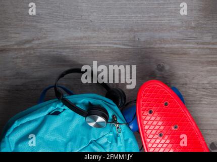 Skateboard con cuffie e una borsa - mezzi alternativi di concetto di trasporto Foto Stock